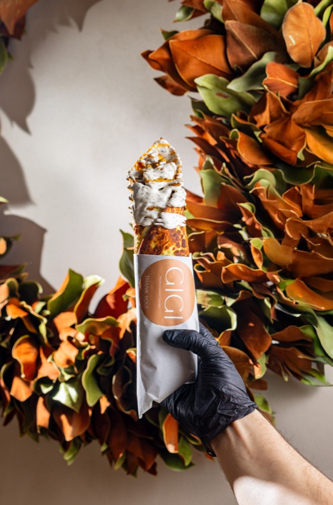 Wrap held in hand with fresh leaves, handheld food shot